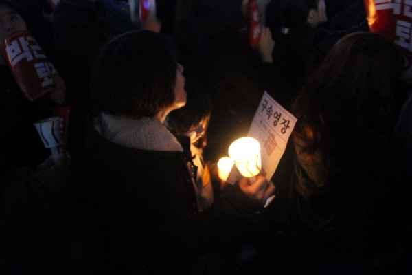  지난 11월 박근혜 전 대통령에 대한 진상촉구를 요구하는 한 촛불집회에서 모녀가 촛불을 들며 시위하고 있다. 